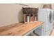 Functional laundry room featuring a wooden folding table with storage and a modern washing machine at 2799 Alnwick Ct, Henderson, NV 89044