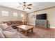 Inviting living room featuring wood-look floors, ceiling fan, and a comfortable brown sectional at 2799 Alnwick Ct, Henderson, NV 89044