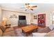 Living room with wood-look flooring, ceiling fan, cozy couch, and a decorative cabinet at 2799 Alnwick Ct, Henderson, NV 89044