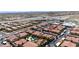 Wide aerial shot showcasing the community's red-tiled roofs, carports, mature trees, pool, nearby highway, and city views at 3360 Cactus Shadow St # 203, Las Vegas, NV 89129