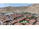 Stunning aerial view of the community featuring red tile roofs, a pool, carports, and desert mountain views at 3360 Cactus Shadow St # 203, Las Vegas, NV 89129