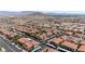 Scenic aerial view of the community featuring red-tiled roofs, mature landscaping, carports, and expansive city and mountain views at 3360 Cactus Shadow St # 203, Las Vegas, NV 89129