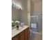 Bright bathroom featuring a double vanity, glass-enclosed shower, and modern fixtures at 3360 Cactus Shadow St # 203, Las Vegas, NV 89129
