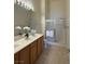 Bright bathroom with double sinks, wood cabinets, neutral flooring, and glass-enclosed shower at 3360 Cactus Shadow St # 203, Las Vegas, NV 89129