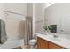 Bright bathroom with white tile, a shower/tub combo, and wood-paneled vanity at 3360 Cactus Shadow St # 203, Las Vegas, NV 89129