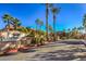 Cliff Shadows community entrance with lush landscaping, palm trees, and clear blue skies at 3360 Cactus Shadow St # 203, Las Vegas, NV 89129