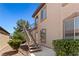 Building exterior featuring a staircase, small balcony, desert landscaping and neutral color scheme at 3360 Cactus Shadow St # 203, Las Vegas, NV 89129
