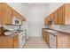 Efficient kitchen features wood cabinetry, white appliances, and spacious countertops on both sides at 3360 Cactus Shadow St # 203, Las Vegas, NV 89129