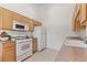 Efficient kitchen features wood cabinetry, white appliances, and spacious countertops on both sides at 3360 Cactus Shadow St # 203, Las Vegas, NV 89129