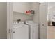Laundry area features a stacked washer and dryer with a shelf and open door at 3360 Cactus Shadow St # 203, Las Vegas, NV 89129