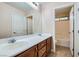 Bright bathroom with a double sink vanity, large mirror and a view into the toilet and tub/shower area at 368 Misty Moonlight St, Henderson, NV 89015