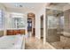 Elegant bathroom with walk-in glass shower, soaking tub, and dual vanity sinks at 368 Misty Moonlight St, Henderson, NV 89015