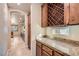 View of butler's pantry featuring granite counters, wood cabinets and wine rack at 368 Misty Moonlight St, Henderson, NV 89015