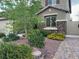 Landscaped front yard with mature trees, colorful flowers, and a brick pathway leading to the home's entrance at 368 Misty Moonlight St, Henderson, NV 89015