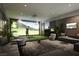 Spacious living room featuring a golf simulator, modern decor, and comfortable seating at 400 Rock Peak Dr # 2301, Henderson, NV 89012