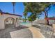 Lush backyard featuring mature palm trees, manicured landscaping, and a charming covered patio area at 4030 Del Monte Ave, Las Vegas, NV 89102