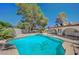 Backyard swimming pool with trees and blue skies in the background at 4030 Del Monte Ave, Las Vegas, NV 89102
