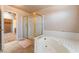 Bathroom featuring a tub with shower and tile flooring, leading to a walk-in closet at 4378 Cherrystone Ct, Las Vegas, NV 89121