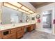 Bathroom vanity with dual sinks, a large mirror, and access to the tub and bedroom at 4378 Cherrystone Ct, Las Vegas, NV 89121