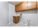 Functional laundry area with wooden cabinets and tile flooring at 4378 Cherrystone Ct, Las Vegas, NV 89121