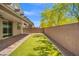 Serene backyard with manicured artificial grass, covered patio, and a brick wall for privacy at 4511 Stardusk Falls Ave, North Las Vegas, NV 89084