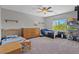 Spacious bedroom with two beds, large dresser, ceiling fan, and natural light from the window at 4511 Stardusk Falls Ave, North Las Vegas, NV 89084