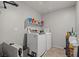 Functional laundry room with washer, dryer, storage shelves, and tiled flooring at 4511 Stardusk Falls Ave, North Las Vegas, NV 89084