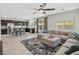 Open-concept living room with modern kitchen, neutral tones, ceiling fan, and lots of natural light at 4511 Stardusk Falls Ave, North Las Vegas, NV 89084