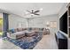 Spacious living room features a large sectional couch, area rug, and ceiling fan at 4511 Stardusk Falls Ave, North Las Vegas, NV 89084