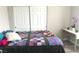 Comfortable bedroom with a colorful quilt, wooden floors, and bright natural light at 4618 Zia Ridge St, North Las Vegas, NV 89031