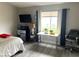 Bright bedroom with gray wood floors, large window, and minimalist decor at 4618 Zia Ridge St, North Las Vegas, NV 89031