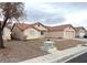 Exterior shot of single story home with desert landscaping, tile roof, and side view of a tree in the yard at 4618 Zia Ridge St, North Las Vegas, NV 89031