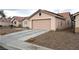 Tan single-story home with a two-car garage, low maintenance desert landscaping, and a long driveway at 4618 Zia Ridge St, North Las Vegas, NV 89031