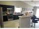 Open kitchen with dark cabinets, stainless steel appliances, bar seating, and sleek flooring at 4618 Zia Ridge St, North Las Vegas, NV 89031