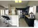 Well-lit kitchen with sleek flooring, dark cabinets, stainless steel appliances, and a bar-style seating area at 4618 Zia Ridge St, North Las Vegas, NV 89031
