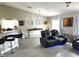 Bright living area featuring sleek flooring, a modern ceiling fan, large windows, and comfortable reclining sofas at 4618 Zia Ridge St, North Las Vegas, NV 89031