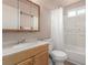 Bathroom with a white tiled shower-tub combination, vanity, mirror, and cabinet at 5109 Gains Mill St, Las Vegas, NV 89122