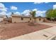 Charming single-story home featuring desert landscaping and a vintage wagon wheel in the front yard at 5109 Gains Mill St, Las Vegas, NV 89122