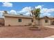 Charming single-story home featuring desert landscaping and a vintage wagon wheel in the front yard at 5109 Gains Mill St, Las Vegas, NV 89122