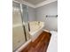 Bright bathroom featuring a glass shower, soaking tub, and wood-look flooring at 5165 Briar Meadow Way, Las Vegas, NV 89118