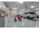 Spacious garage with epoxy flooring, white cabinets, and a white SUV parked inside, with additional vehicles at 52 Innisbrook Ave, Las Vegas, NV 89113