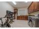 Functional laundry and exercise area featuring a sink, storage, and modern machines at 52 Innisbrook Ave, Las Vegas, NV 89113