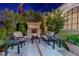 Cozy outdoor seating area with fireplace and lush greenery, perfect for relaxation and entertaining at 52 Innisbrook Ave, Las Vegas, NV 89113