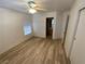 Neutral bedroom with wood-look floors leads to a closet and an attached bathroom at 5474 Jacobs Field St, Las Vegas, NV 89148