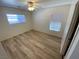 Bright bedroom with light, wood-look flooring, a ceiling fan, and natural light from two windows at 5474 Jacobs Field St, Las Vegas, NV 89148
