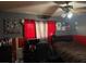 A cozy bedroom with red accents and a ceiling fan, furnished with a bed and desk at 5804 Balzar Ave, Las Vegas, NV 89108