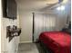 A modern bedroom with a red bedspread, mounted TV, and floating shelf at 5804 Balzar Ave, Las Vegas, NV 89108