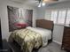 A bright bedroom with a floral comforter, modern shutters, and a neutral color scheme at 5804 Balzar Ave, Las Vegas, NV 89108