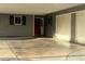 Home exterior featuring a covered parking area with a red front door and dark shutters at 5804 Balzar Ave, Las Vegas, NV 89108