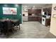 A spacious kitchen is shown, with dark cabinets, stainless steel appliances, and a dining table set for six at 5804 Balzar Ave, Las Vegas, NV 89108